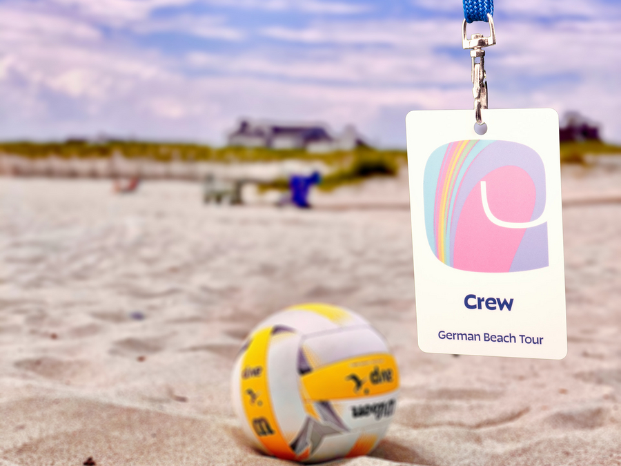 Strandszene mit Akkreditierungskarte am Lanyard im Vordergrund